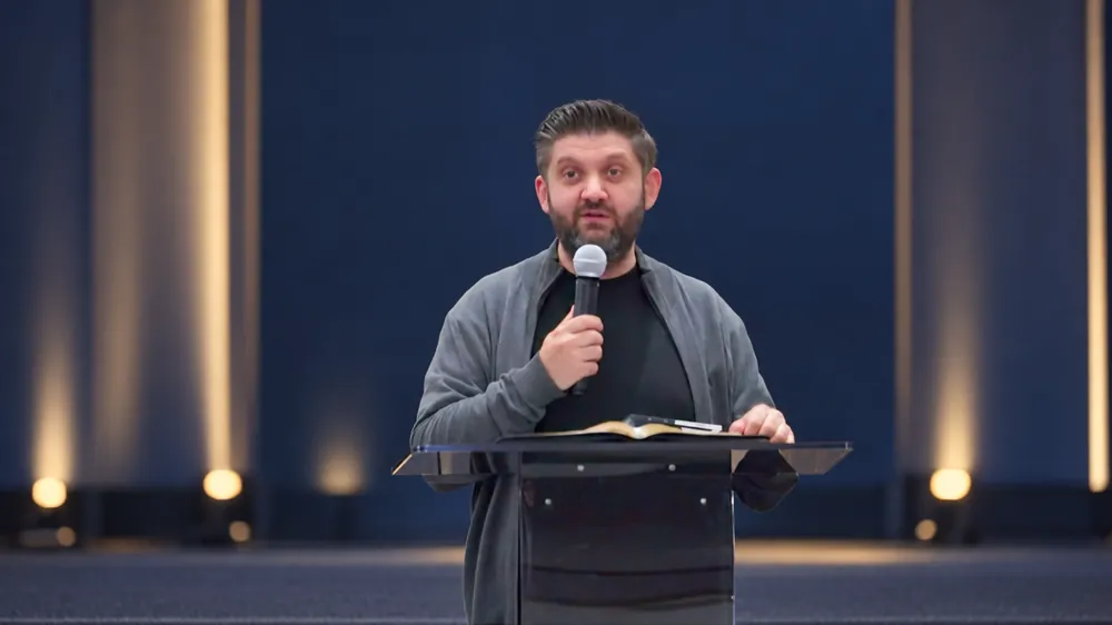 Ioan Caraian speaking at a microphone on stage